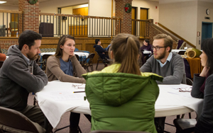 students and faculty talking around a table